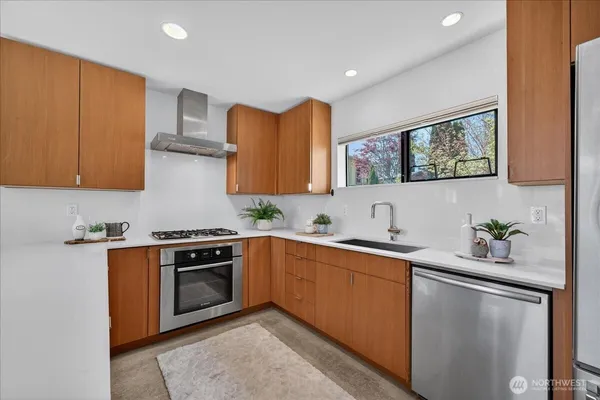a kitchen with stainless steel appliances granite countertop a sink stove and cabinets