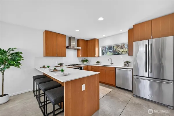 a kitchen with stainless steel appliances a sink a stove a refrigerator cabinets and a counter top space