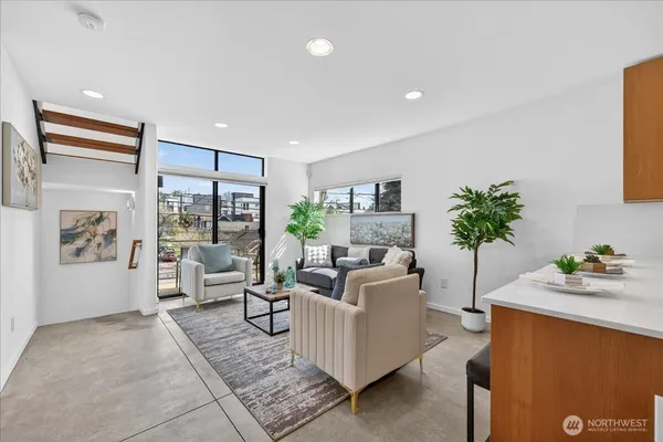 a living room with furniture potted plant and a large window