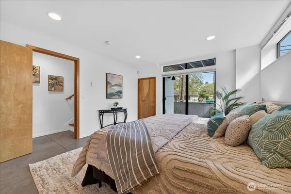 a bedroom with a large bed and a wooden floor