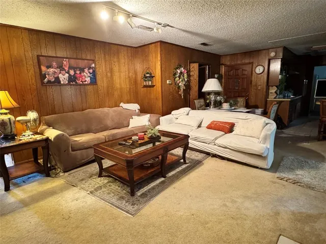 a living room with furniture a rug and kitchen view