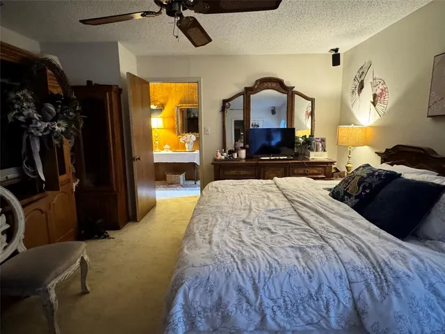 a bedroom with a bed a mirror on dresser and a window