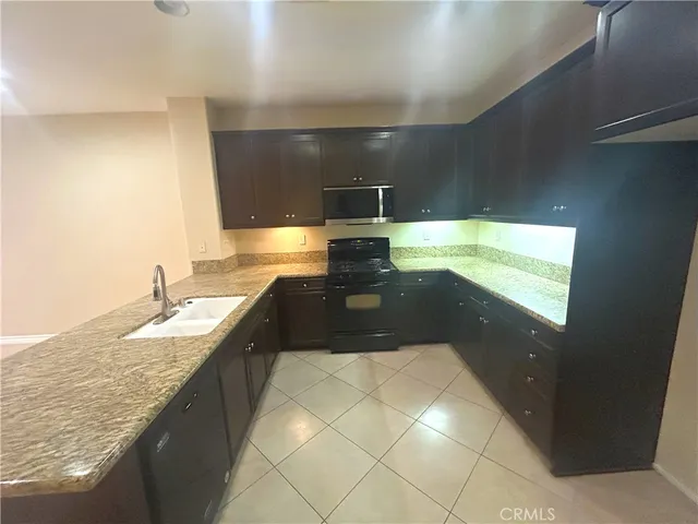 a bathroom with a granite countertop sink a toilet and a large mirror