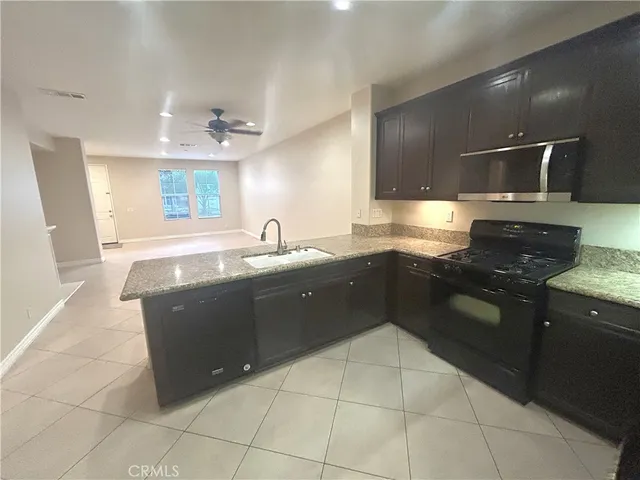 a kitchen with a sink a stove top oven and cabinets