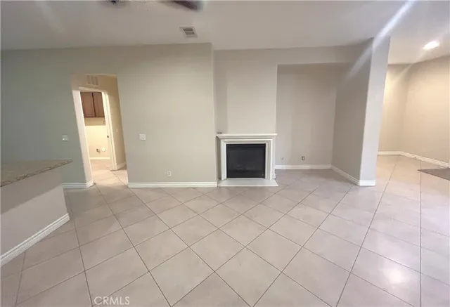 an empty room with fireplace and windows