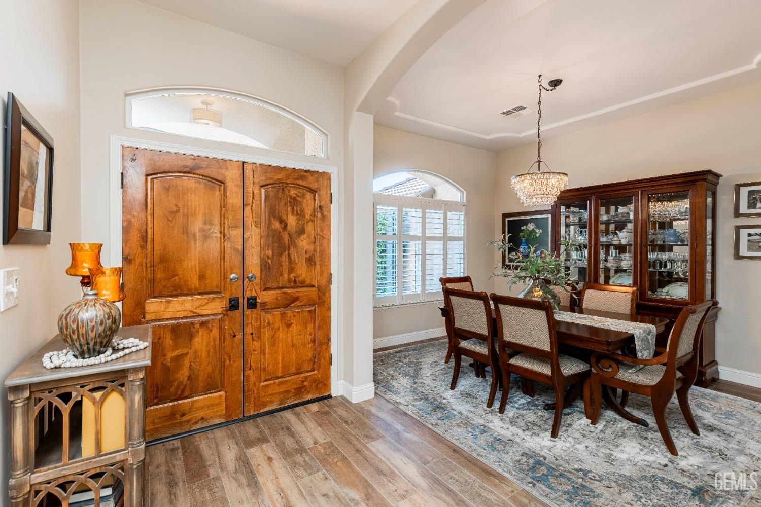 Undisclosed Address Bakersfield, CA 93312 - Photo 11 of 51 a dining room with wooden floor a chandelier a wooden table and chairs