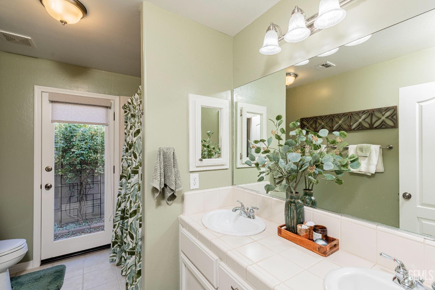 Undisclosed Address Bakersfield, CA 93312 - Photo 20 of 51 a bathroom with a sink a mirror and a shower