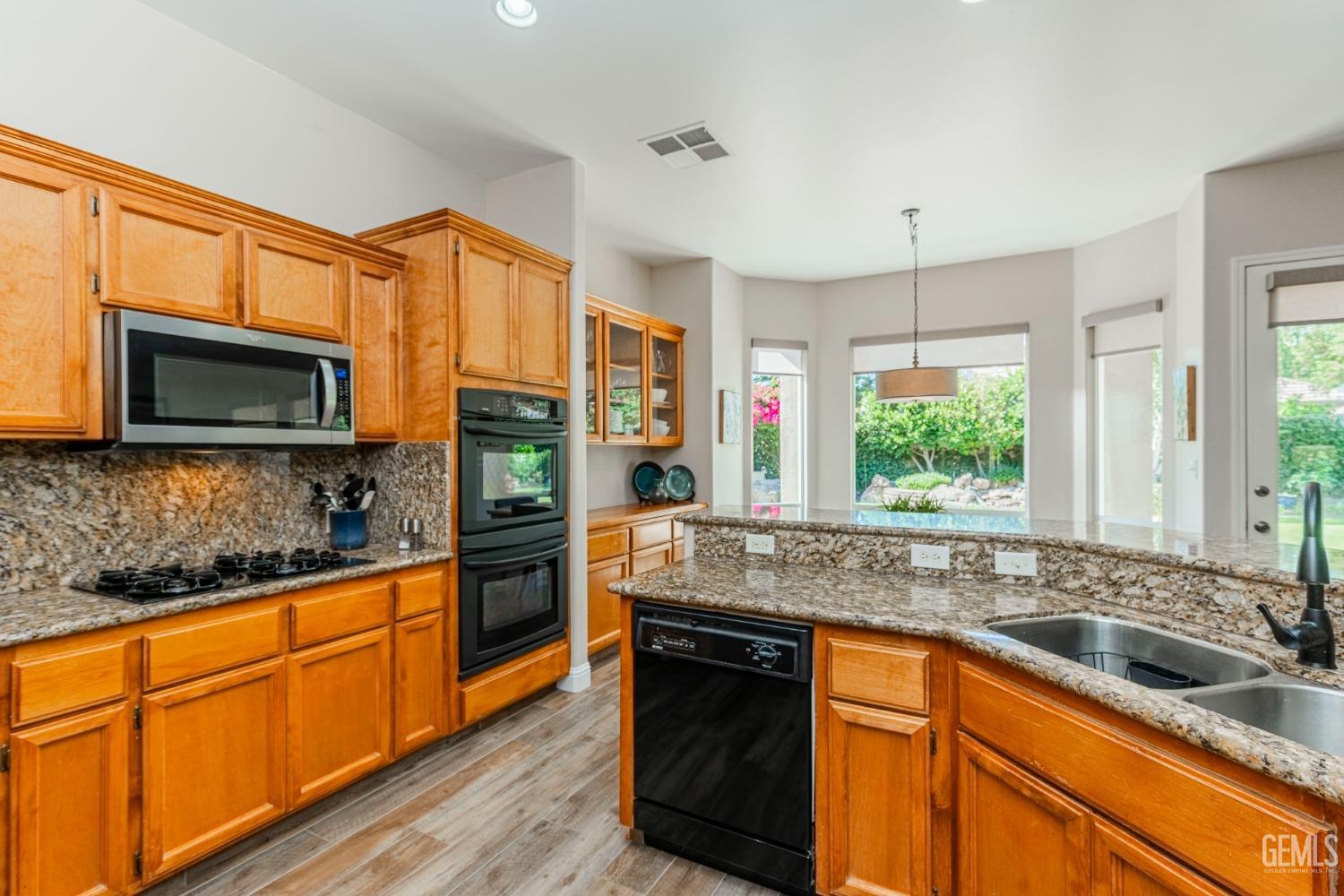 Undisclosed Address Bakersfield, CA 93312 - Photo 26 of 51 a kitchen with stainless steel appliances granite countertop a sink stove and microwave