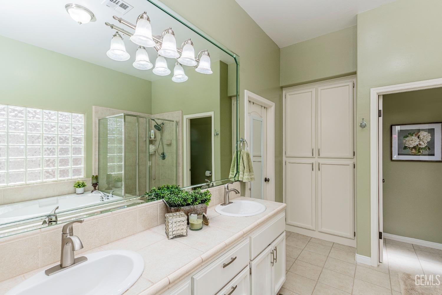 Undisclosed Address Bakersfield, CA 93312 - Photo 38 of 51 a bathroom with a granite countertop sink a large mirror and a shower