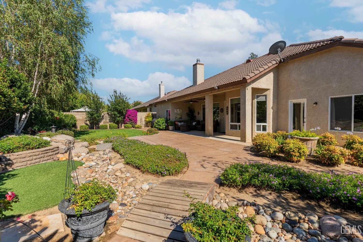 Undisclosed Address Bakersfield, CA 93312 - Photo 46 of 51 a front view of a house with a yard and potted plants