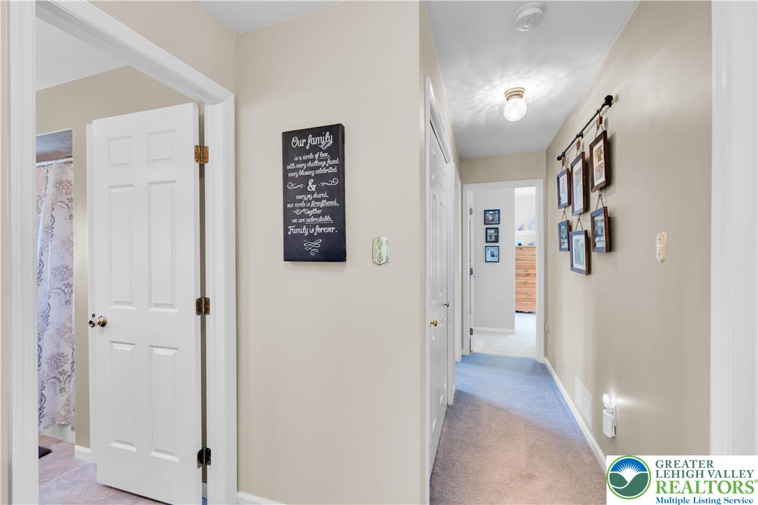 4059 Old Sentry Road Allentown, PA 18104 - Photo 26 of 39 A well-lit corridor welcomes you home, showcasing soft carpet and a charming wall display.