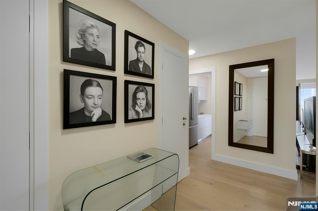6 Horizon Road, Unit 2602 Fort Lee, NJ 07024 - Photo 3 of 45 a view of a hallway with paintings on the wall