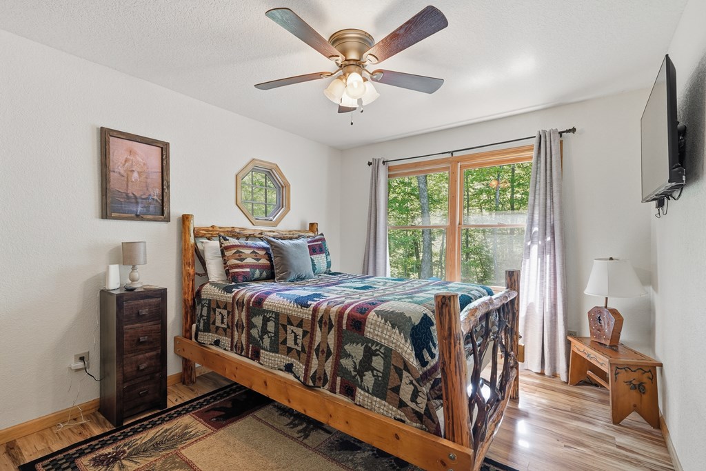 445 Tranquil Cove Road Murphy, NC 28906 - Photo 44 of 91 a bedroom with a bed and a chandelier