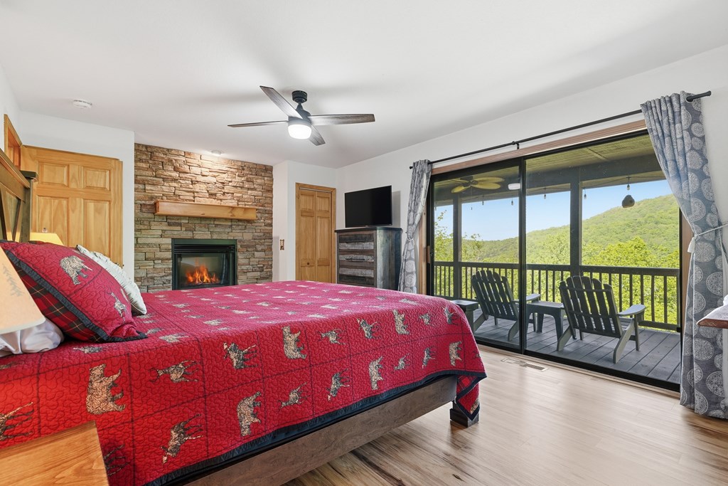 445 Tranquil Cove Road Murphy, NC 28906 - Photo 54 of 91 a bedroom with a bed and a fireplace