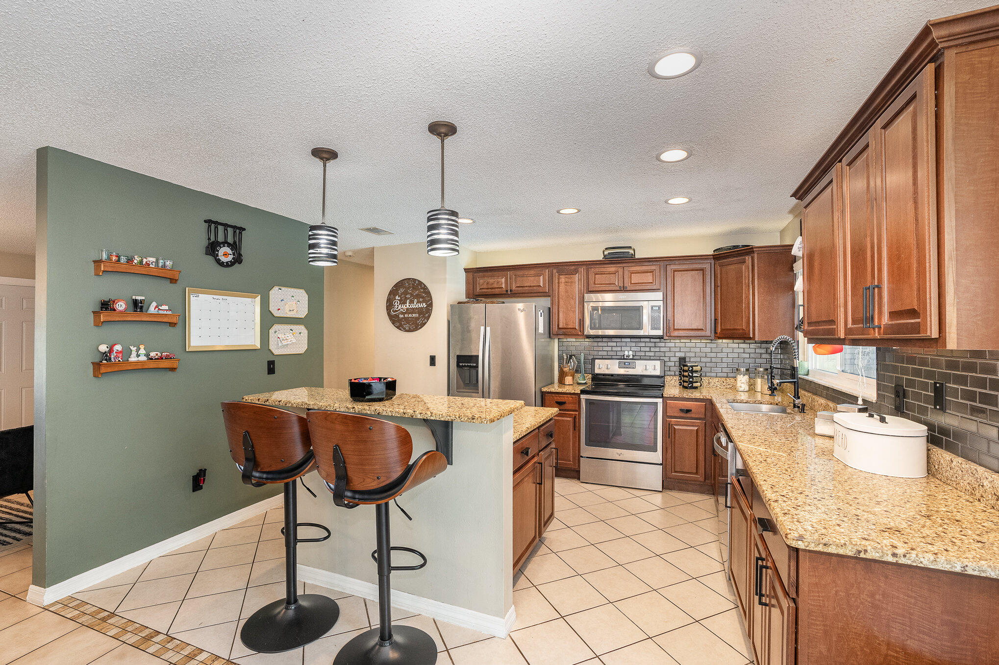 1420 Creel Road Northeast Palm Bay, FL 32905 - Photo 7 of 27 a kitchen with stainless steel appliances granite countertop a sink a stove and a refrigerator
