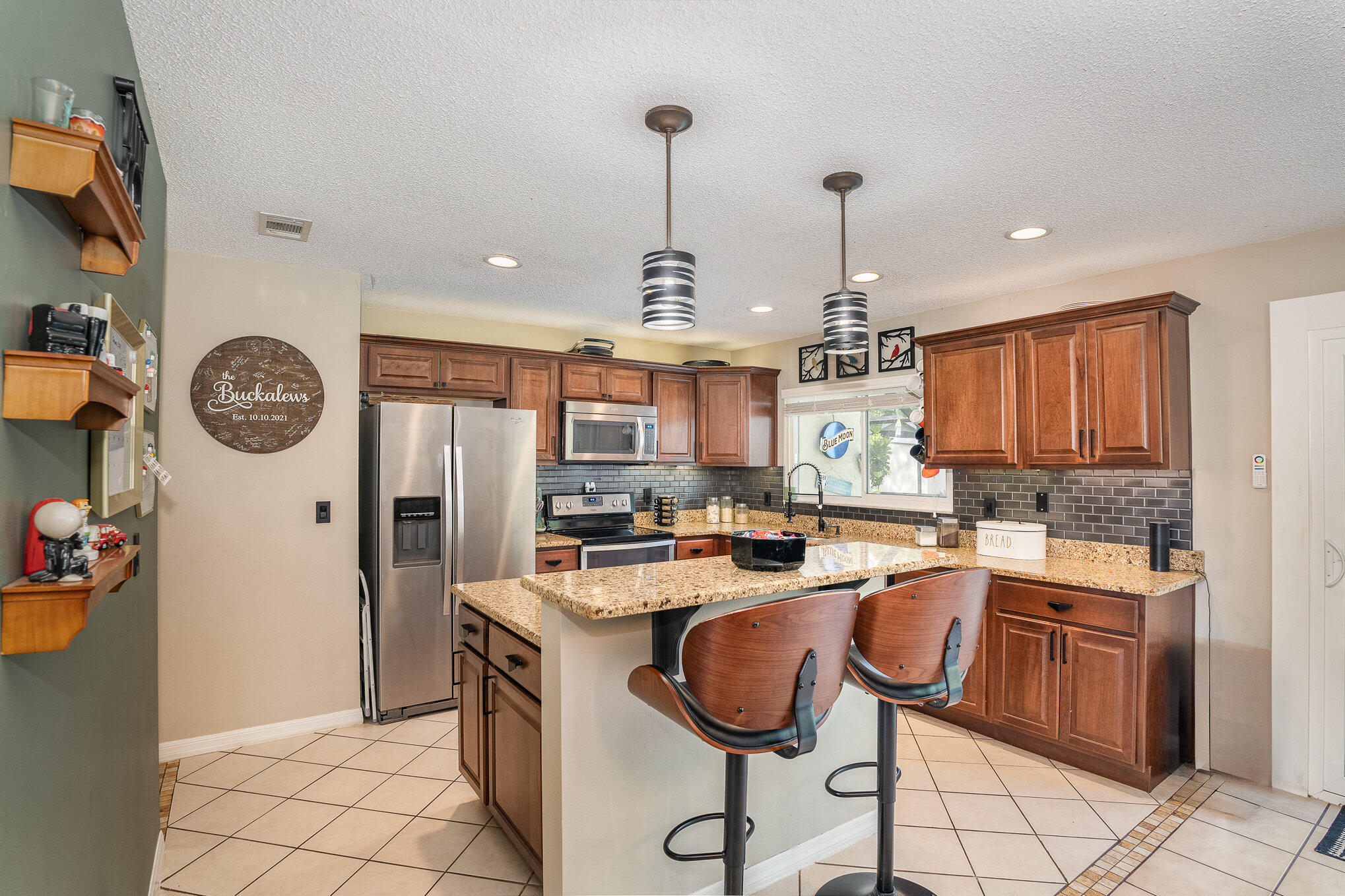 1420 Creel Road Northeast Palm Bay, FL 32905 - Photo 8 of 27 a kitchen that has a lot of cabinets in it and stainless steel appliances