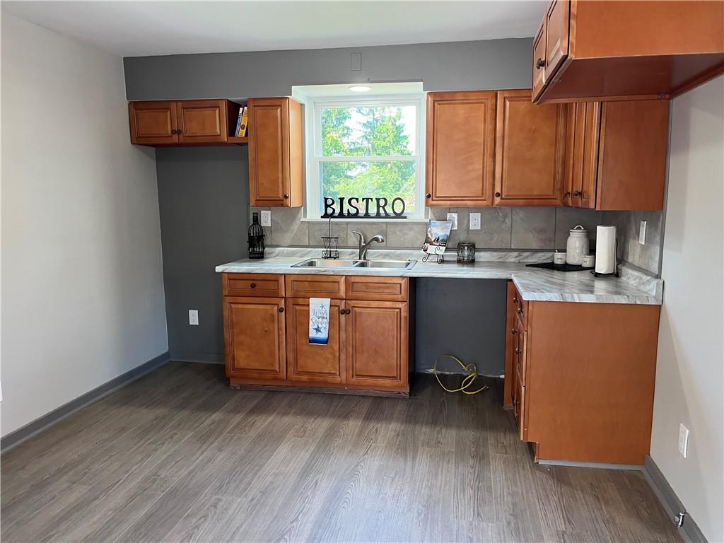 500 Scene Ridge Road McKeesport, PA 15133 - Photo 6 of 26 a kitchen with stainless steel appliances granite countertop a sink a stove and wooden floors