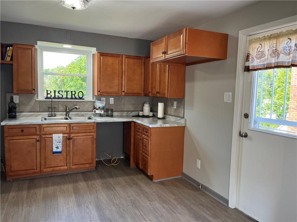 500 Scene Ridge Road McKeesport, PA 15133 - Photo 7 of 26 a kitchen with stainless steel appliances granite countertop a sink a stove a refrigerator with grey cabinets and wooden floor