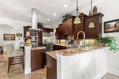 a kitchen with stainless steel appliances kitchen island granite countertop a sink and cabinets