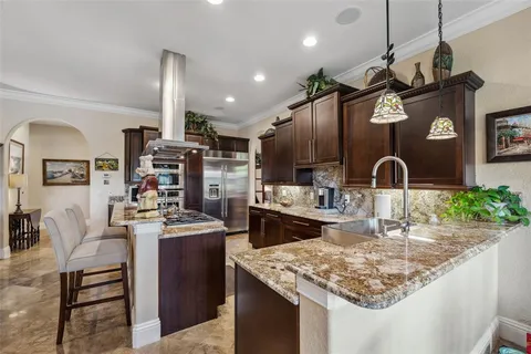 a kitchen with stainless steel appliances granite countertop a sink stove and refrigerator