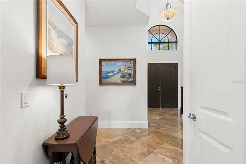 a view of a patio with table and chairs potted plants and floor to ceiling window