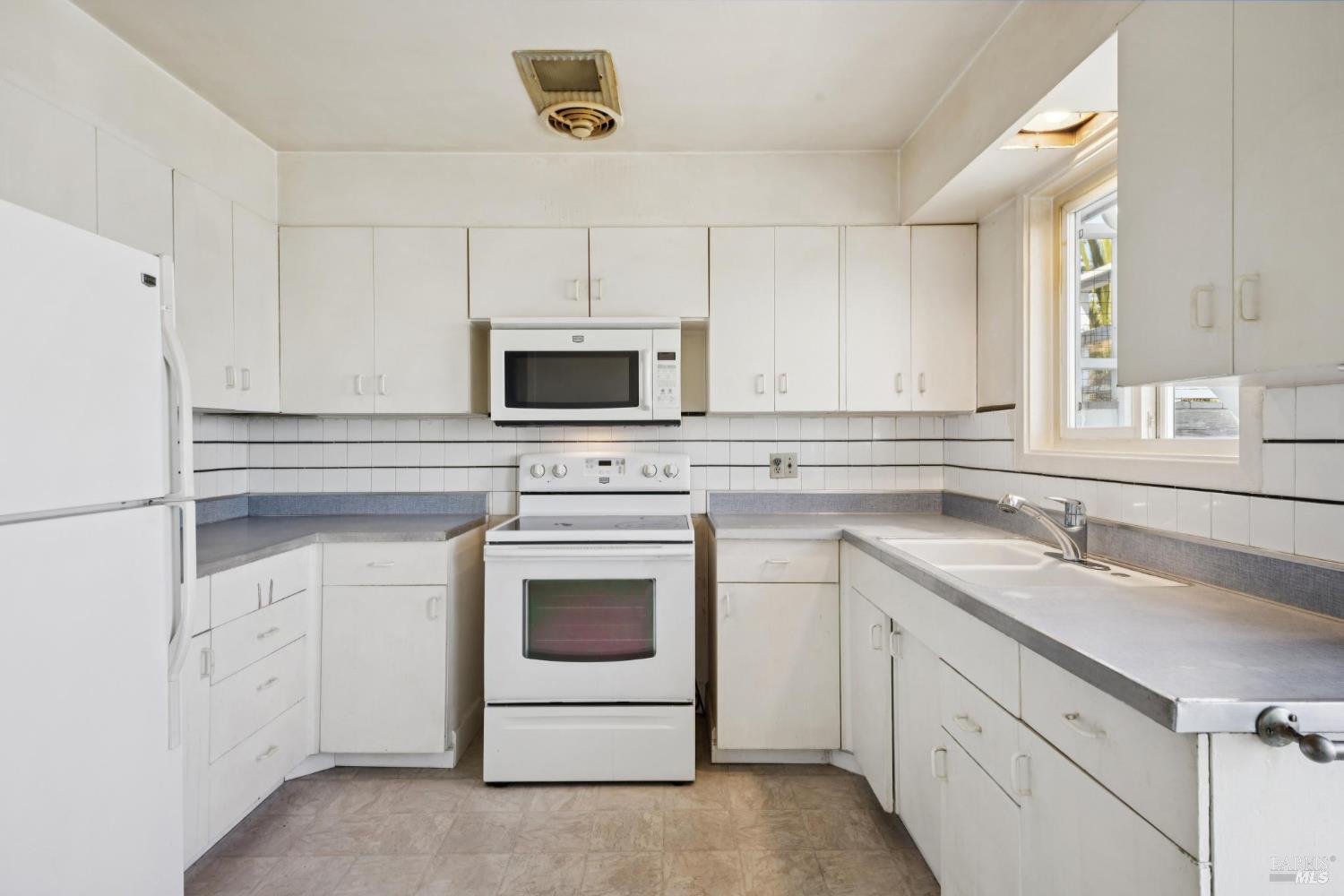 836 Point San Pedro Road San Rafael, CA 94901 - Photo 38 of 83 a kitchen with white cabinets appliances and sink