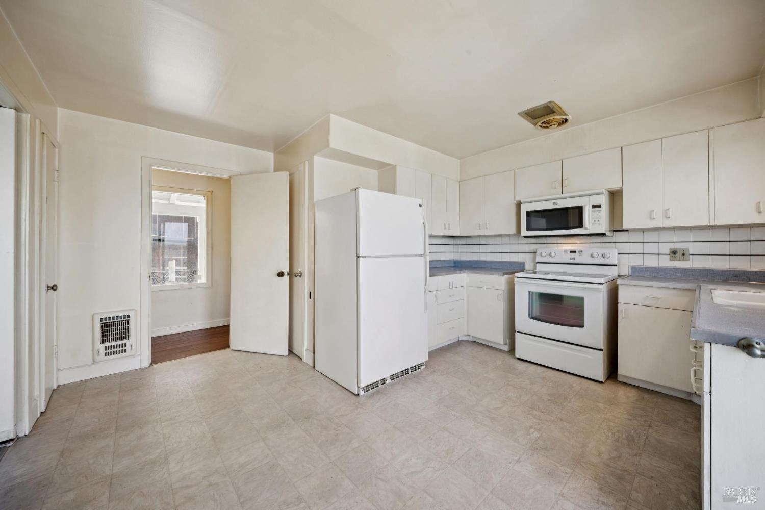 836 Point San Pedro Road San Rafael, CA 94901 - Photo 42 of 83 a kitchen with white cabinets and stainless steel appliances