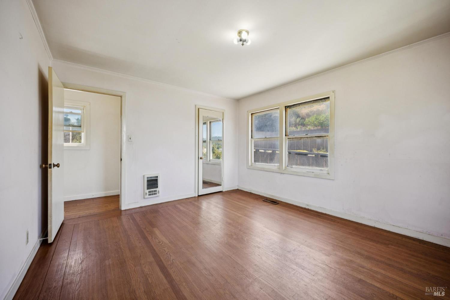 836 Point San Pedro Road San Rafael, CA 94901 - Photo 54 of 83 a view of an empty room with wooden floor and a window