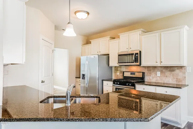 a kitchen with stainless steel appliances granite countertop a sink a stove and a microwave