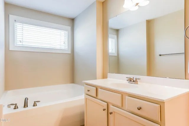 a bathroom with a tub sink and mirror