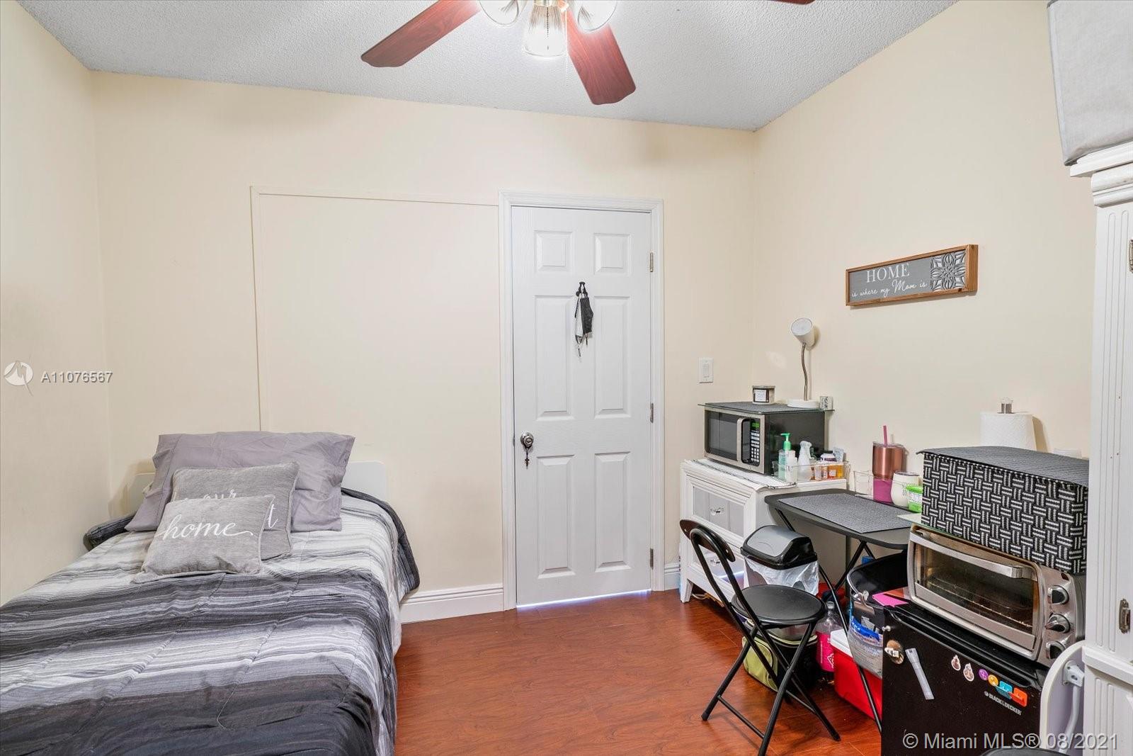 153 Granada Avenue Weston, FL 33326 - Photo 15 of 37 a bedroom with a bed and a chandelier