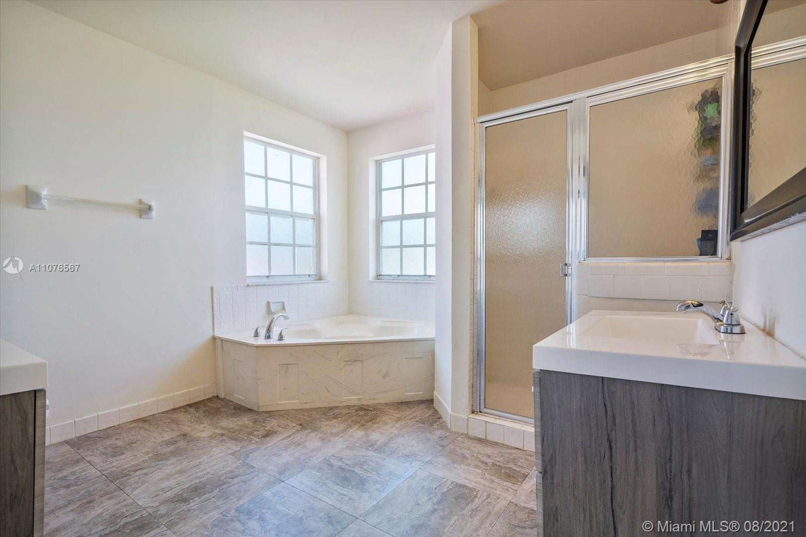 153 Granada Avenue Weston, FL 33326 - Photo 18 of 37 a bathroom with a bathtub sink and mirror