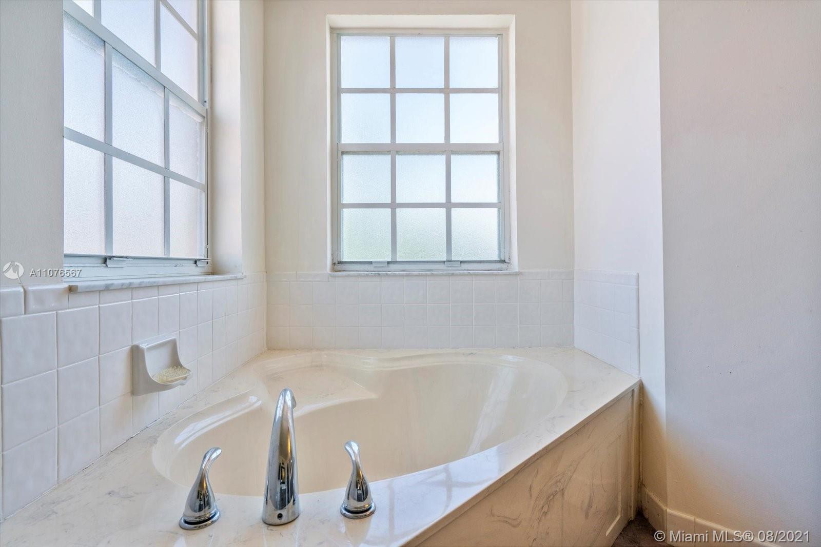 153 Granada Avenue Weston, FL 33326 - Photo 20 of 37 a bath tub sitting next to a window