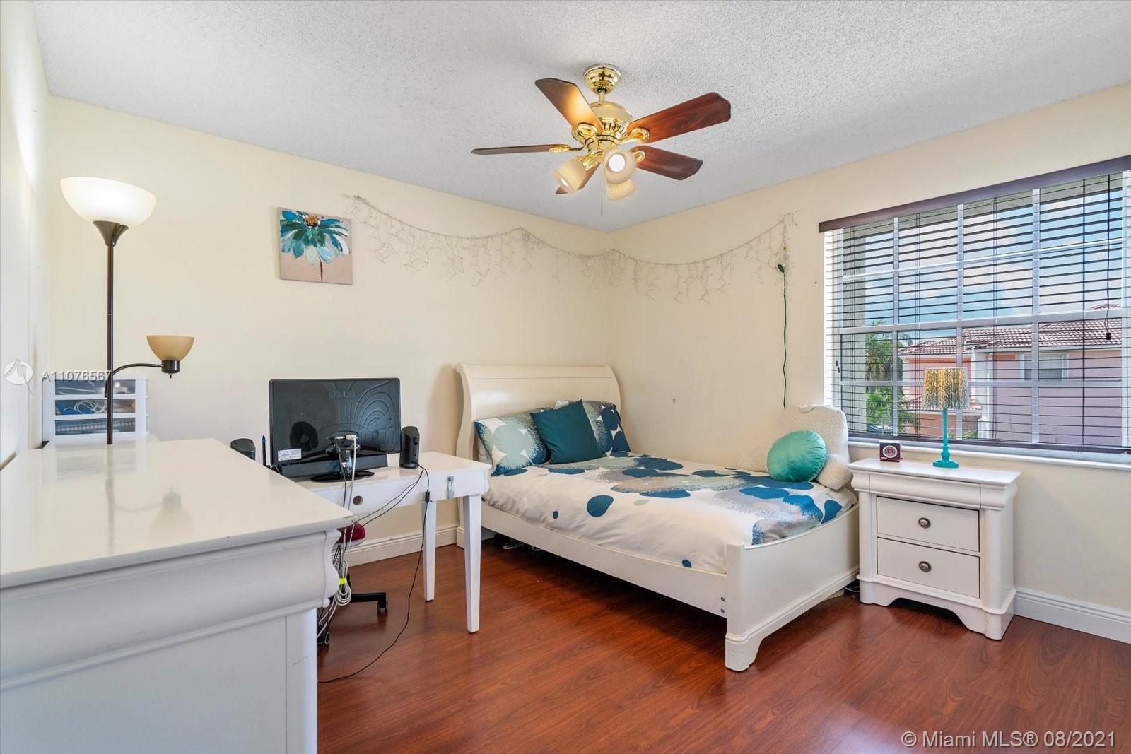 153 Granada Avenue Weston, FL 33326 - Photo 21 of 37 a bedroom that has a bed and a table in it