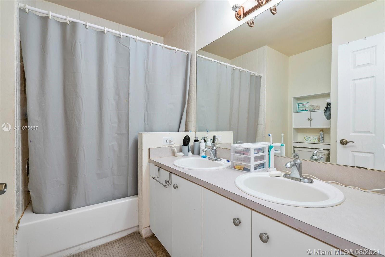 153 Granada Avenue Weston, FL 33326 - Photo 23 of 37 a bathroom with a double vanity sink and mirror