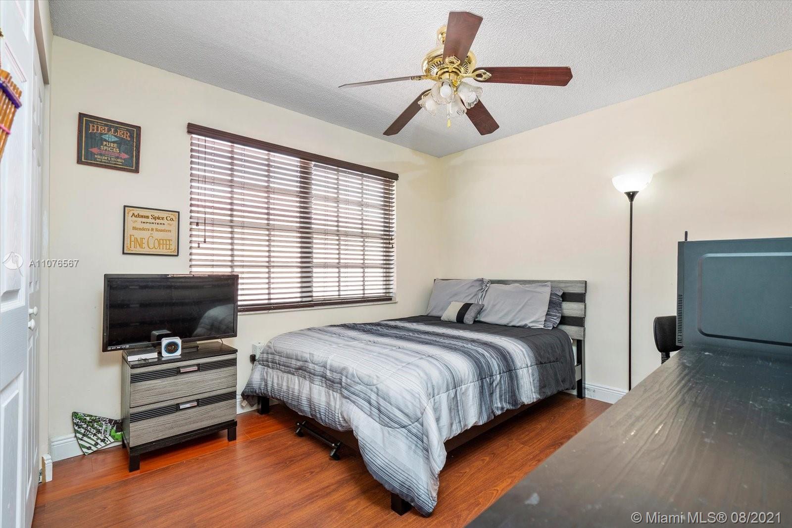 153 Granada Avenue Weston, FL 33326 - Photo 25 of 37 a bedroom with a bed and a flat screen tv