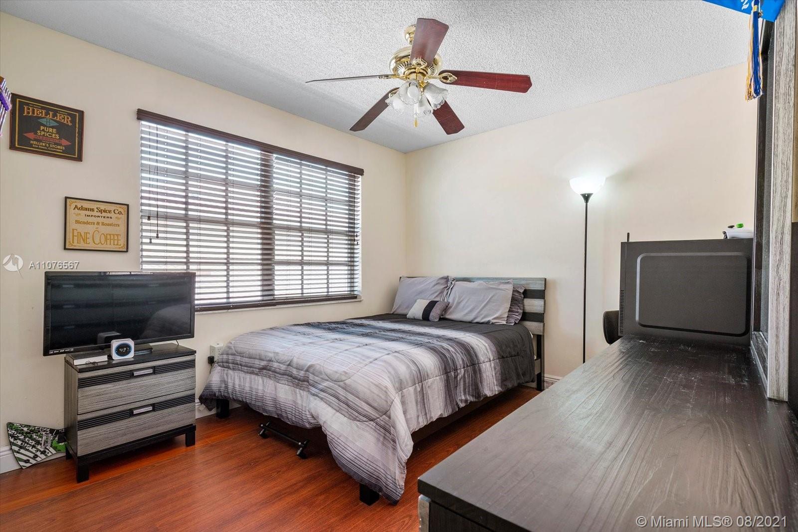 153 Granada Avenue Weston, FL 33326 - Photo 26 of 37 a spacious bedroom with a bed and a flat screen tv