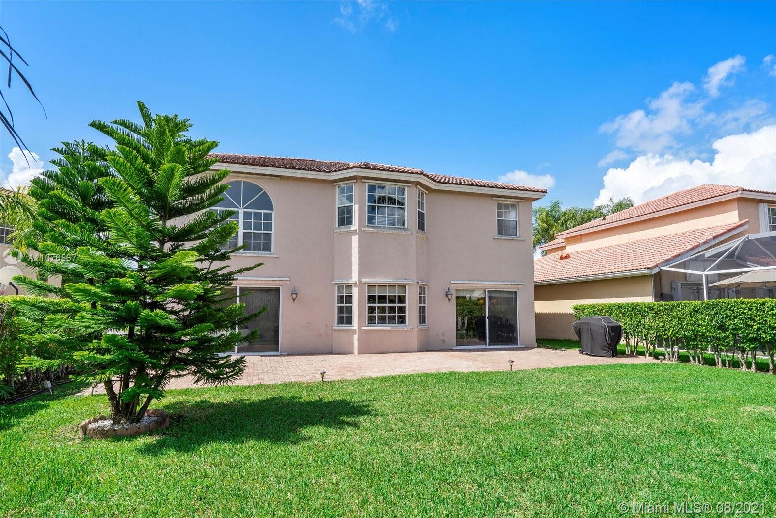 153 Granada Avenue Weston, FL 33326 - Photo 31 of 37 a front view of a house with a garden