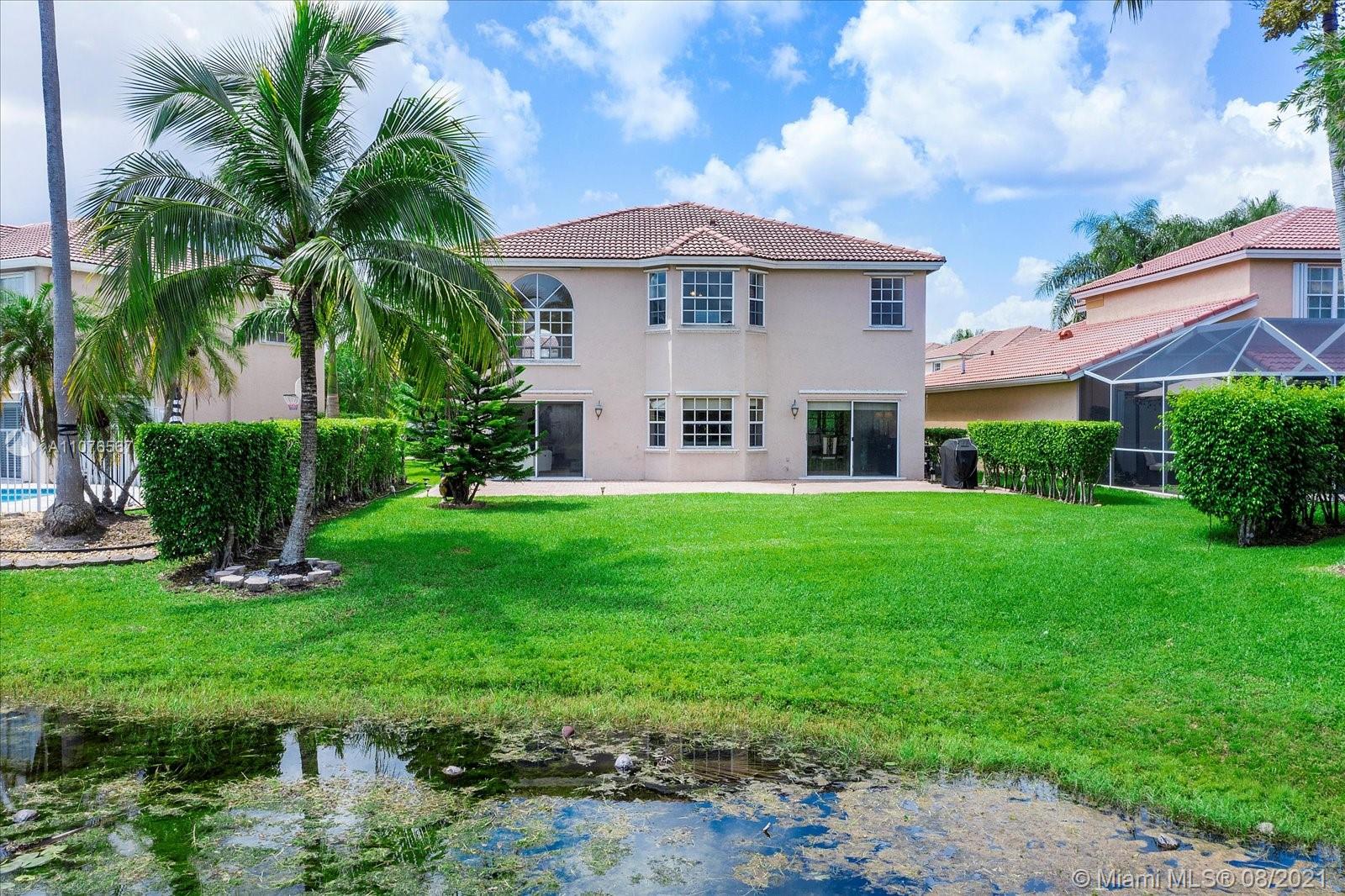 153 Granada Avenue Weston, FL 33326 - Photo 32 of 37 a large tree in front of a house next to a yard