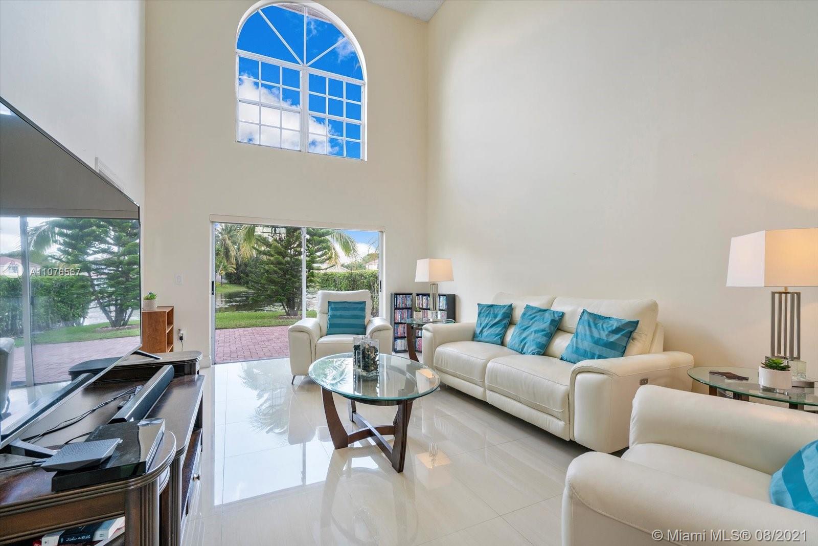 153 Granada Avenue Weston, FL 33326 - Photo 5 of 37 a living room with furniture and a floor to ceiling window