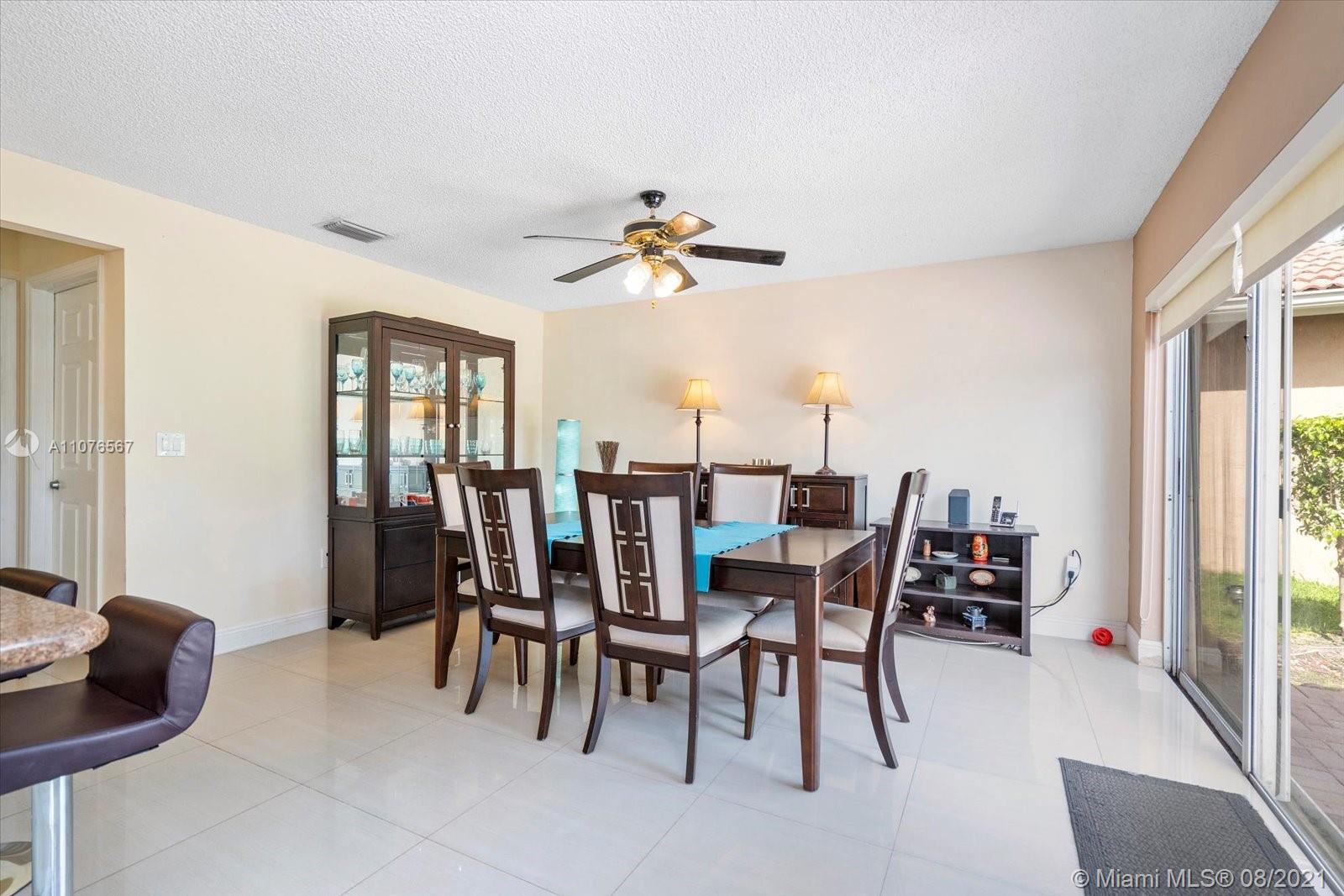 153 Granada Avenue Weston, FL 33326 - Photo 10 of 37 a dining room with furniture garden view and a chandelier
