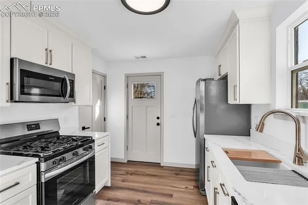 a kitchen with granite countertop a sink and a stove top oven