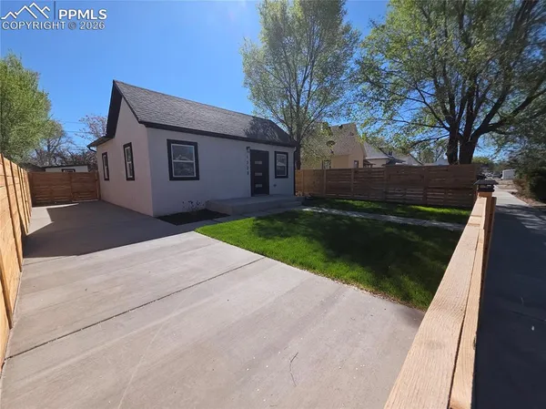 a front view of a house with a yard and trees