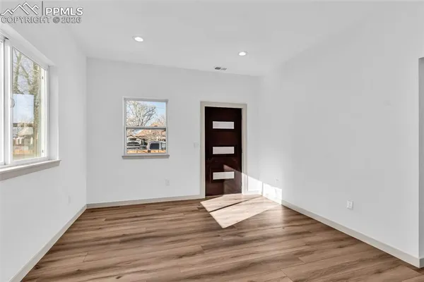 a view of a room with wooden floor and window