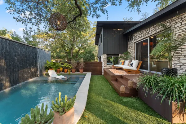 a view of a backyard with plants and outdoor seating