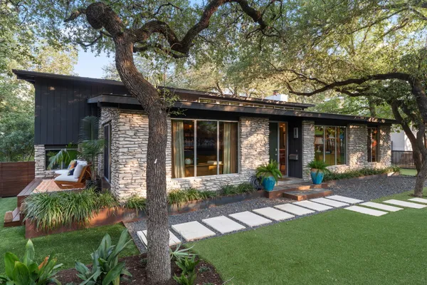 a view of a house with backyard and sitting area