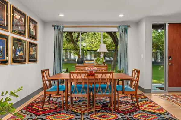 a dining room with furniture a rug and a large window