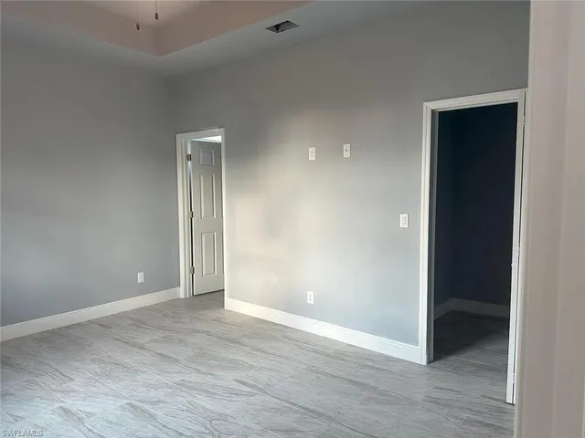 a view of an empty room with wooden floor and closet