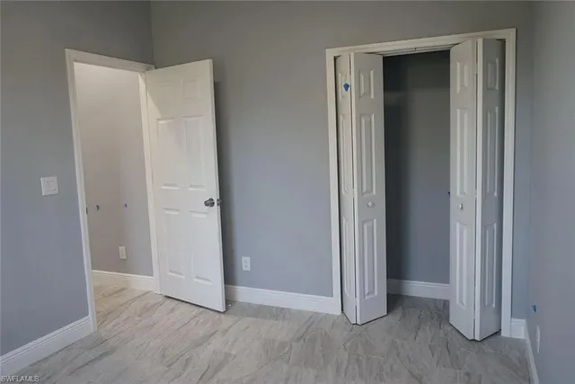 an empty room with wooden floor and closet area
