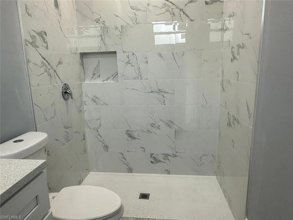 742 Eisenhower Boulevard Lehigh Acres, FL 33974 - Photo 8 of 11 a bathroom with a toilet and a shower